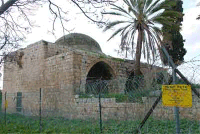 photo of small stone mosque behind barbed wire fence